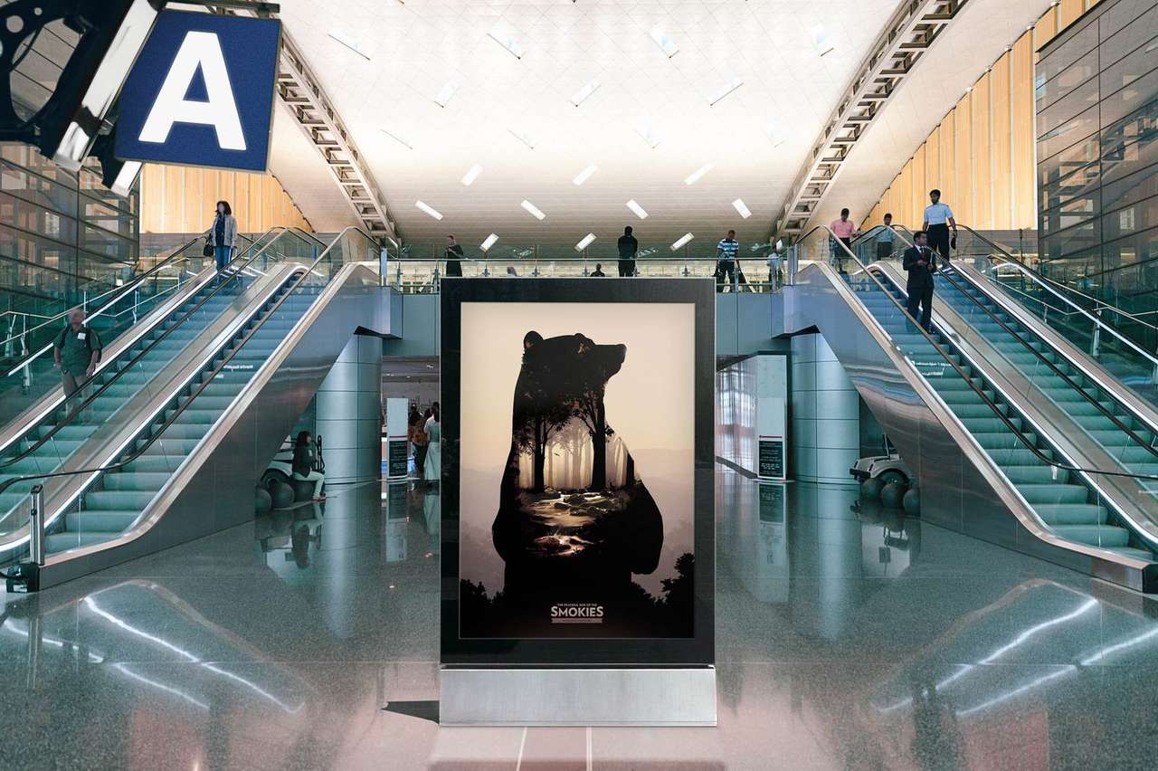 Peaceful Side of the Smokies bear key art on an airport standee